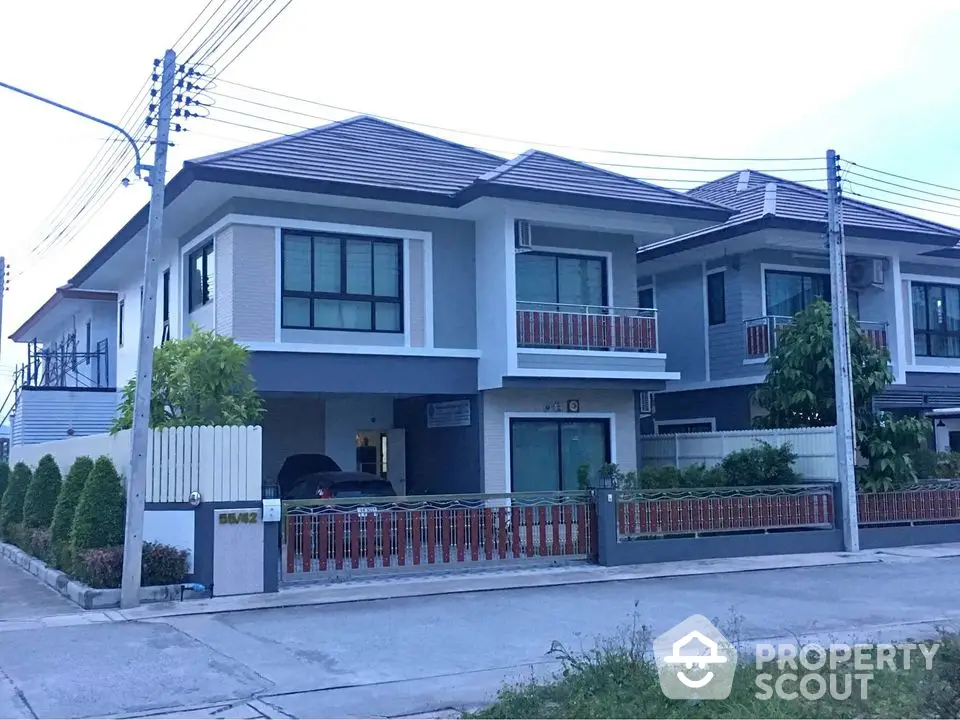 Modern two-story house with sleek design and spacious driveway in suburban neighborhood.