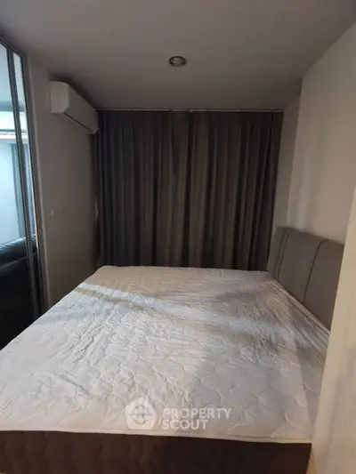 Cozy bedroom with large bed and modern air conditioning unit, perfect for restful nights.