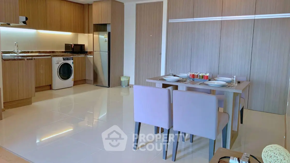 Modern kitchen and dining area with sleek appliances and stylish wooden cabinetry.