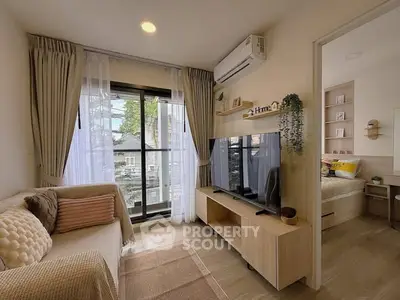 Cozy living room with modern decor and large window, adjacent to a stylish bedroom.