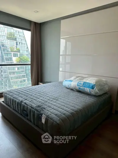 Modern bedroom with large window and stylish decor in urban apartment