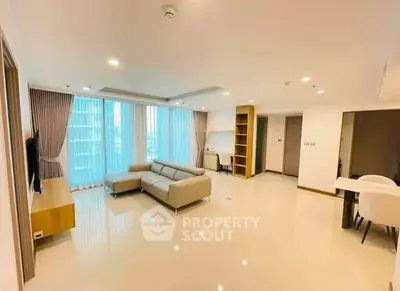 Spacious modern living room with large windows and elegant furnishings in a high-rise apartment.