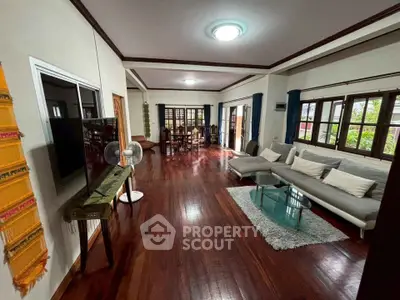 Spacious living room with hardwood floors and modern furniture in a stylish home.