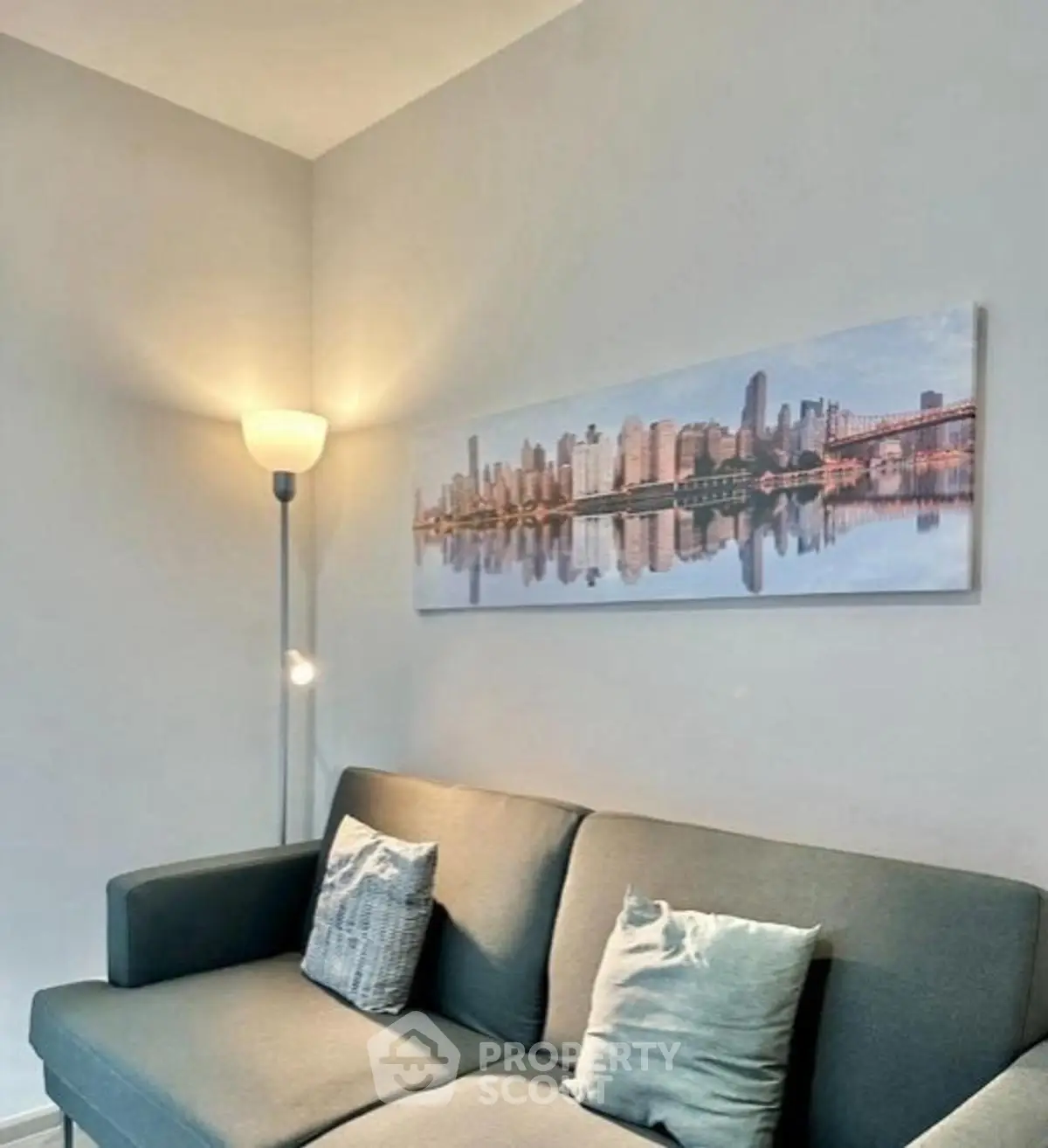 Cozy living room with modern sofa and cityscape artwork, perfect for urban living.