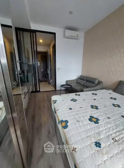 Modern bedroom with stylish decor and mirrored wardrobe in a cozy apartment.