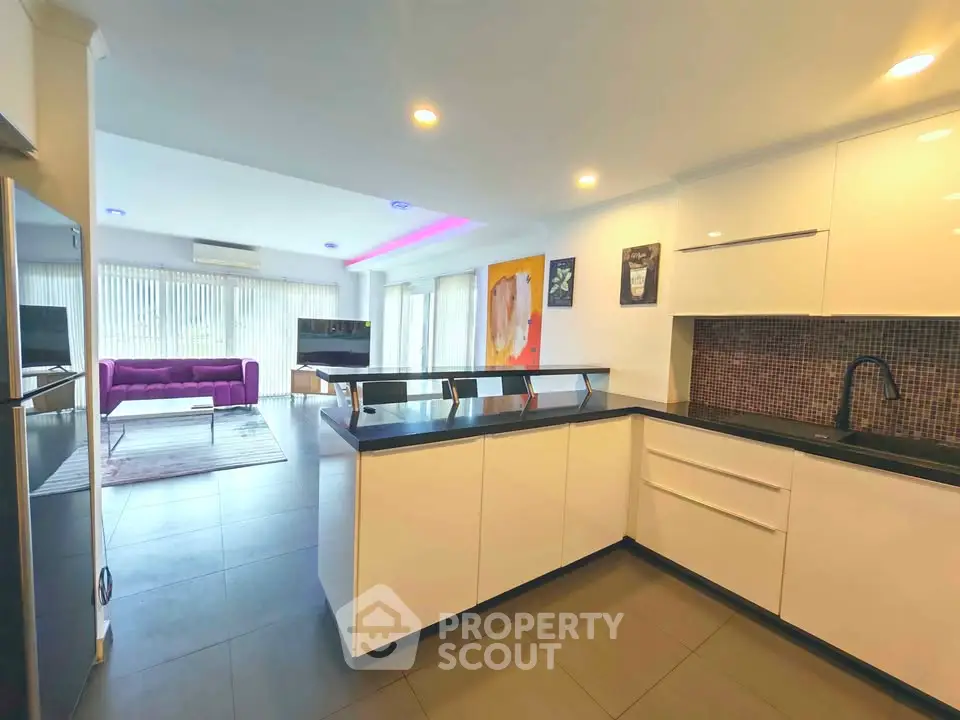 Modern open-layout kitchen with sleek design and spacious living area, perfect for contemporary living.