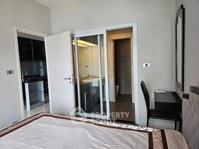 Modern bedroom with ensuite bathroom and sleek kitchen view