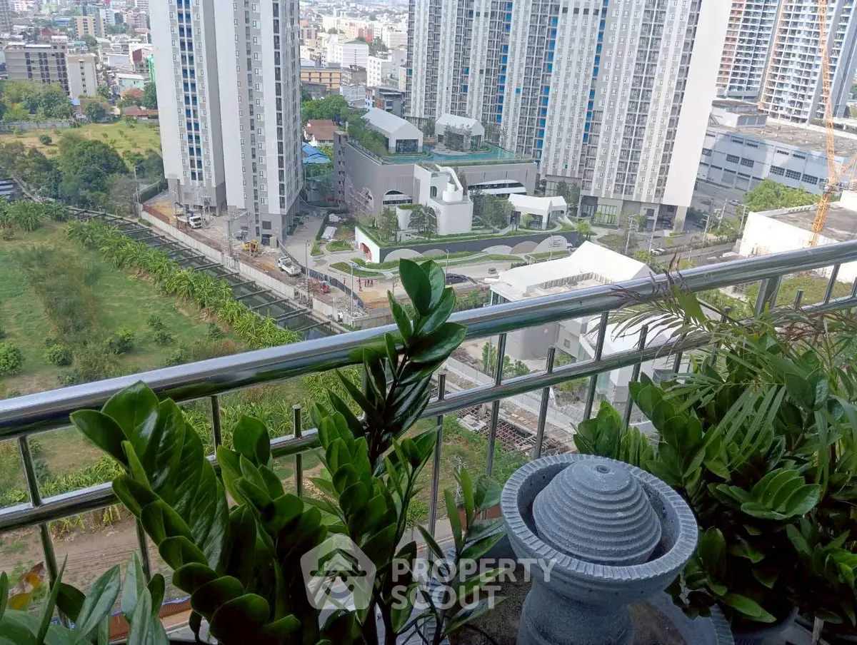 Stunning cityscape view from a high-rise balcony with lush greenery and modern buildings.