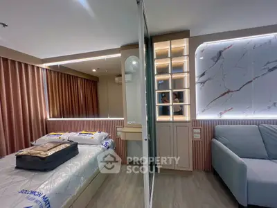 Modern bedroom with stylish decor, featuring a comfortable bed, elegant lighting, and a cozy seating area.