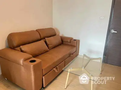 Cozy living room with modern brown leather sofa and glass coffee table