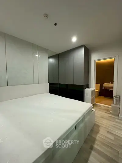 Modern bedroom with sleek design and ensuite bathroom in luxury apartment