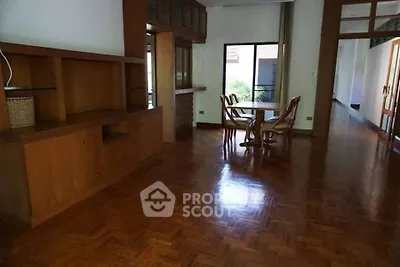 Spacious living room with wooden flooring and dining area, perfect for family gatherings.