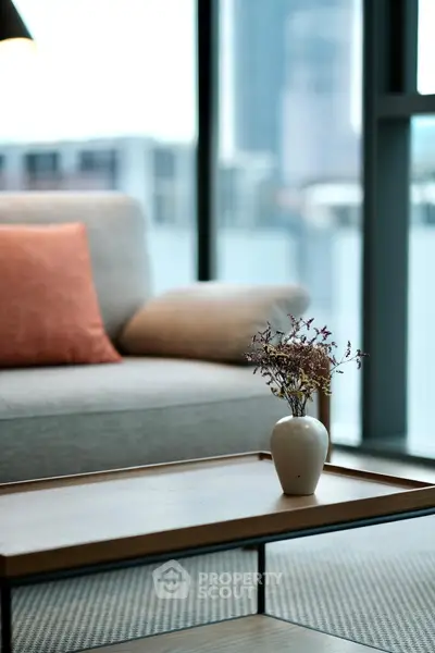 Modern living room with stylish sofa and elegant coffee table in high-rise apartment.