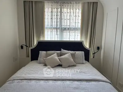Cozy bedroom with elegant headboard and soft lighting, perfect for relaxation.
