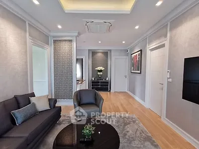 Elegant living room with modern decor, featuring a cozy sofa, stylish armchair, and chic wall accents.