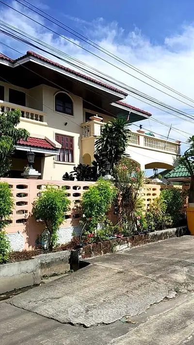 Charming two-story house with lush garden and spacious balcony, perfect for family living.