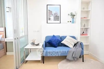 Charming living room with blue sofa, modern decor, and cozy ambiance in a stylish apartment.