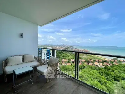 Stunning balcony with ocean view and cozy seating area in modern apartment.