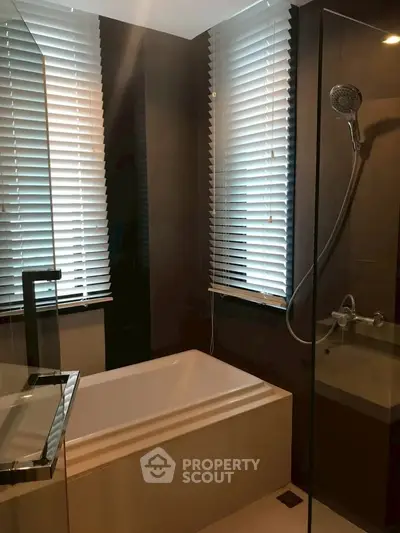 Modern bathroom with sleek design and bathtub, featuring stylish blinds and a glass shower enclosure.