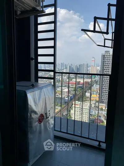 Stunning city view from high-rise balcony with laundry area, perfect for urban living.