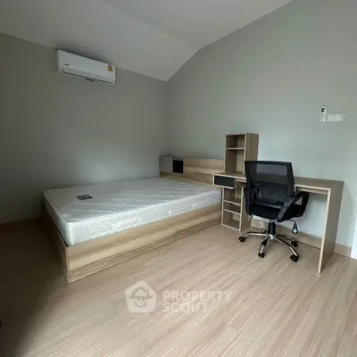 Modern minimalist bedroom with wooden flooring and study desk