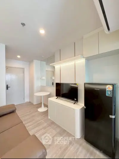 Modern living room with sleek furniture and appliances, featuring a cozy sofa and stylish decor.