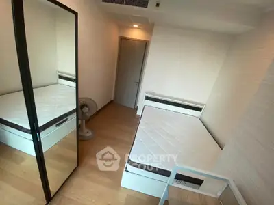 Cozy minimalist bedroom with mirrored wardrobe and wooden flooring