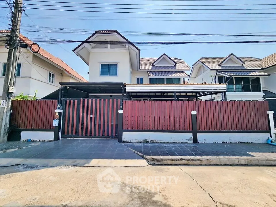 Charming suburban house with gated entrance and tiled driveway, perfect for family living.