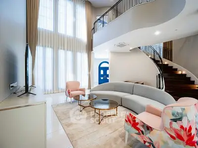 Luxurious modern living room with high ceilings and elegant spiral staircase.