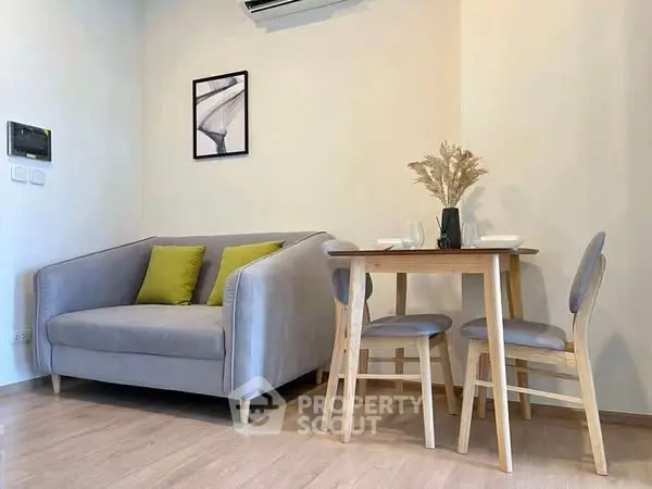 Cozy living room with modern sofa and dining area, perfect for small apartments.