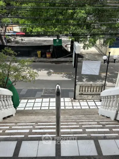 Charming exterior staircase leading to a vibrant street view, perfect for urban living enthusiasts.