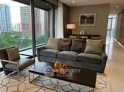 Modern living room with large windows and city view, featuring stylish furniture and decor.