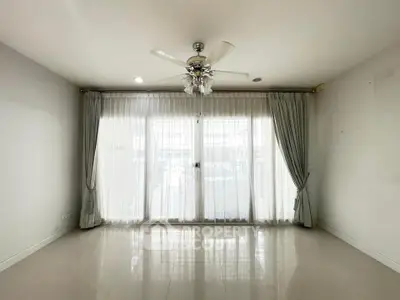Spacious empty living room with elegant curtains and ceiling fan