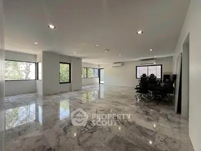Spacious modern living room with marble flooring and large windows for natural light.