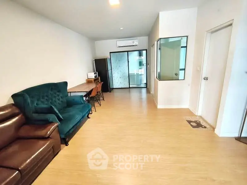Spacious living room with modern furniture and wooden flooring in a stylish apartment.