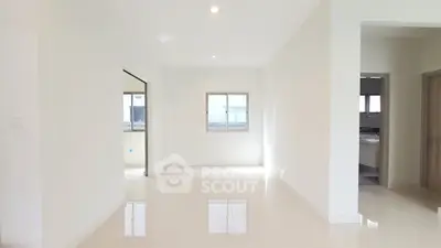 Spacious and bright interior with glossy floors and large windows in modern home.