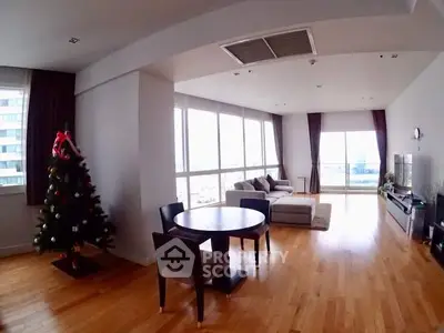Spacious living room with hardwood floors and large windows offering city views.