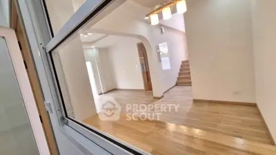 Spacious modern interior with wooden flooring and elegant lighting, perfect for stylish living.