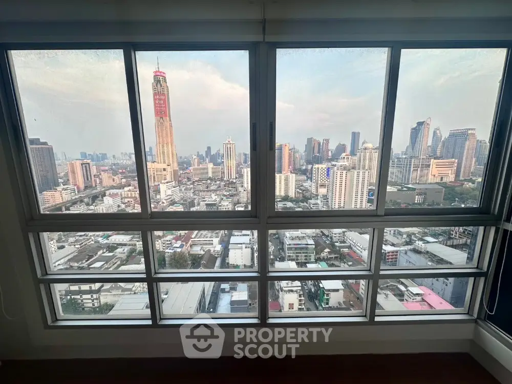 Stunning cityscape view from high-rise apartment window showcasing urban skyline.