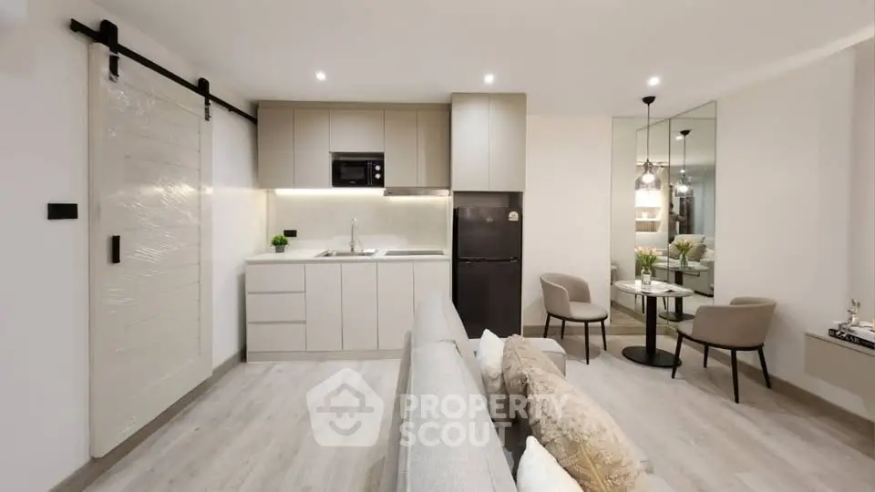 Modern open-plan living room and kitchen with sleek design and cozy seating area.