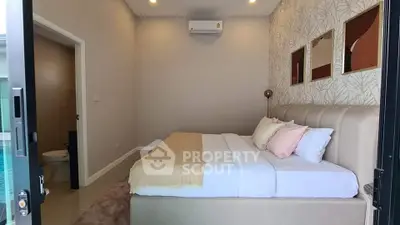 Modern bedroom with elegant decor and ensuite bathroom in a stylish home.