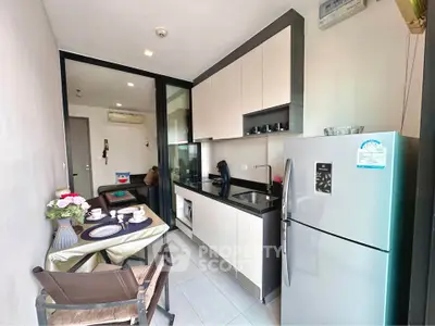 Modern kitchen with sleek cabinetry and dining area in a stylish apartment