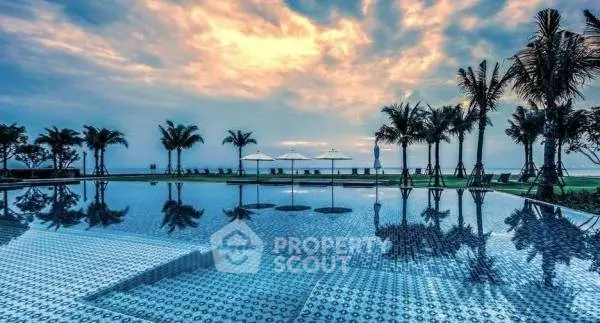 Luxurious beachfront pool with stunning ocean view and palm trees at sunset.
