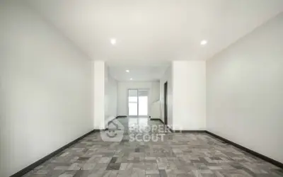 Spacious empty room with tiled flooring and white walls, ideal for customization.