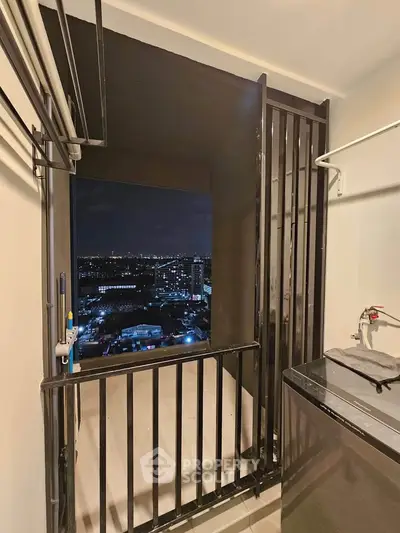 Modern balcony with stunning city night view, featuring sleek railing and laundry area.