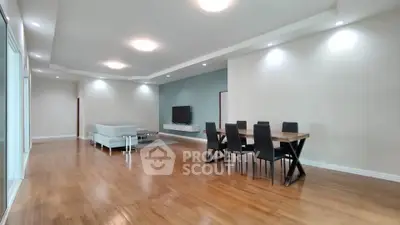 Spacious modern living room with elegant dining area and sleek wooden flooring.