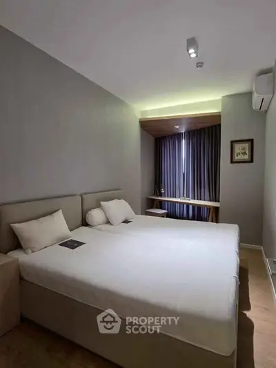 Modern bedroom with cozy lighting and minimalist decor, featuring a comfortable bed and stylish furnishings.