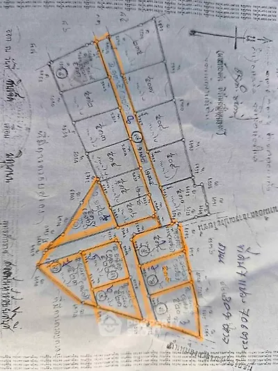 Hand-drawn real estate plot map with numbered lots and street layout.