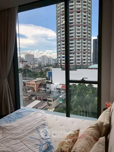 Stunning city view from a cozy bedroom with large windows and modern decor.