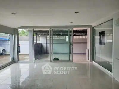 Spacious modern living room with large glass doors opening to a patio, perfect for natural light and outdoor access.